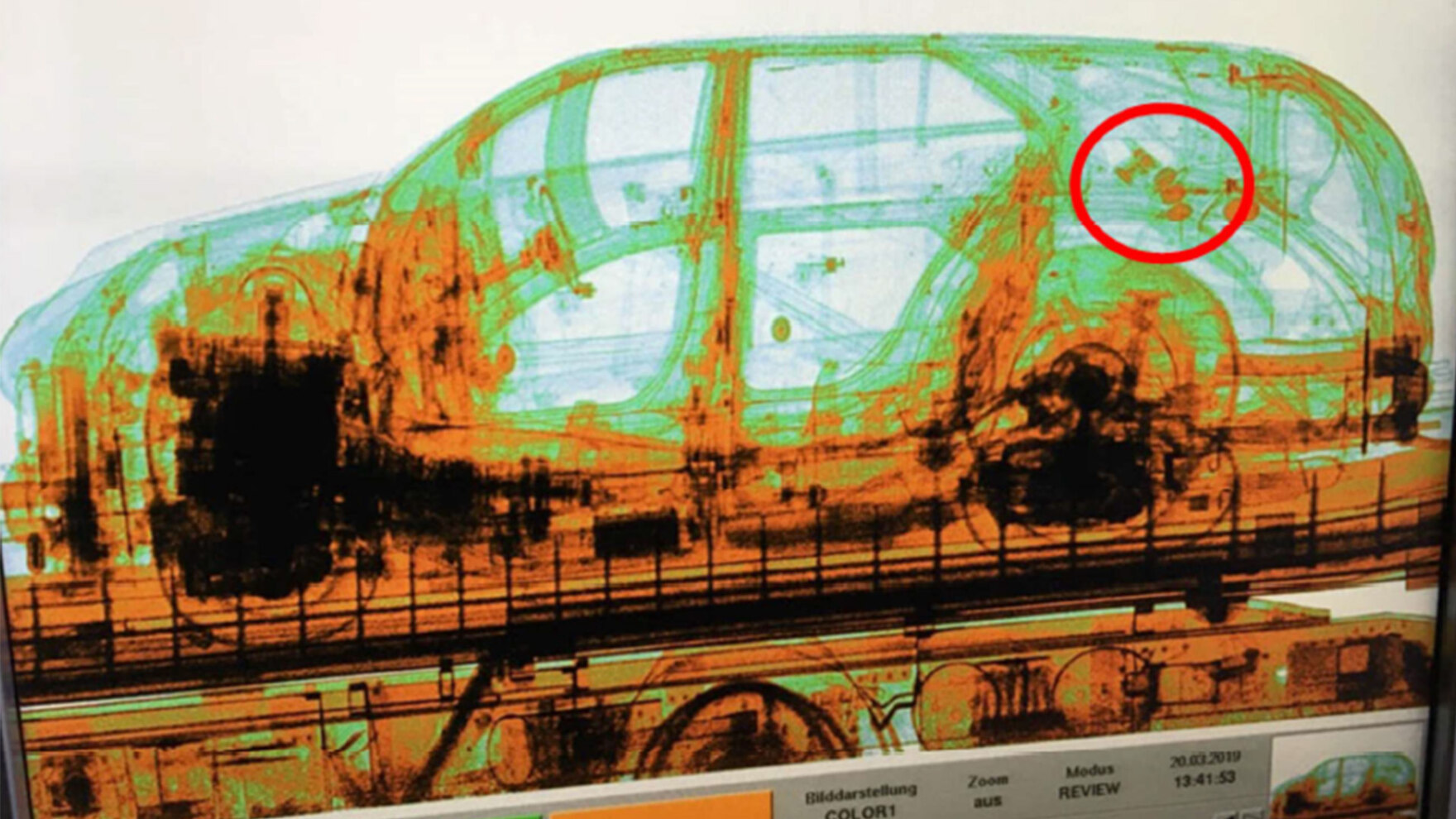 Eine Röntgenaufnahme eines Autos in Grün- und Orange-Tönen zeigt, wo in Hohlräumen des Wagens Granaten versteckt wurden. Einige dieser Granaten sind mit einem roten Kreis gekennzeichnet.