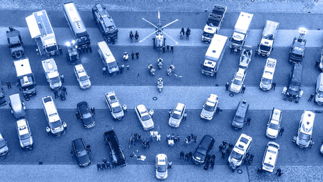 Aus der Vogelperspektive fotografiert sind die unterschiedlichen Bereiche der Polizei Sachsen. Es ist ein Hubschrauber zu sehen, viele unterschiedliche Fahrzeuge wie Streifenwagen bis zu Wasserwerfer, Motorräder und Busse. Daneben die Bediensteten.