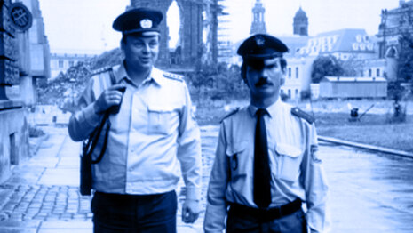 Das Foto von 1991 zeigt zwei Polizisten auf einem Fußweg in Dresden. Sie tragen unterschiedliche Uniformen, da sie aus Sachsen und Bayern stammen.